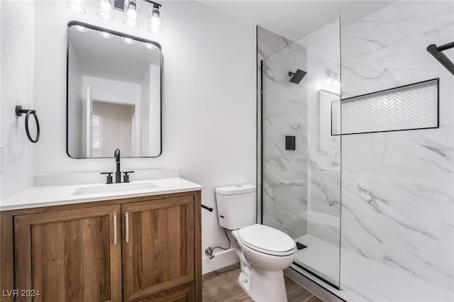 bathroom with a shower with shower door, vanity, toilet, and wood-type flooring