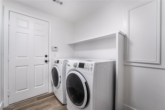 washroom featuring hardwood / wood-style floors and washer and dryer