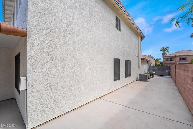 view of side of property with cooling unit and a patio