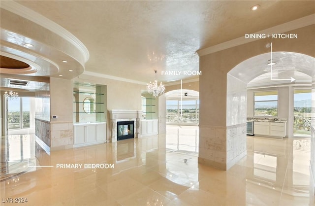 9103 Alta Dr Unit 401, Las Vegas, NV 89145 - unfurnished living room featuring ornamental molding, a high end fireplace, arched walkways, recessed lighting, and a wainscoted wall