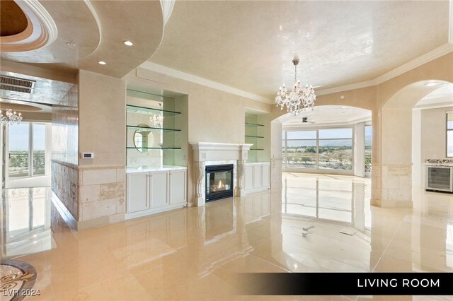 9103 Alta Dr Unit 401, Las Vegas, NV 89145 - unfurnished living room featuring a chandelier, crown molding, a glass covered fireplace, arched walkways, and tile patterned floors