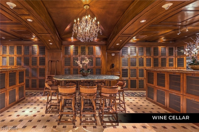 wine cellar featuring ornamental molding, a chandelier, wood ceiling, wooden walls, and vaulted ceiling