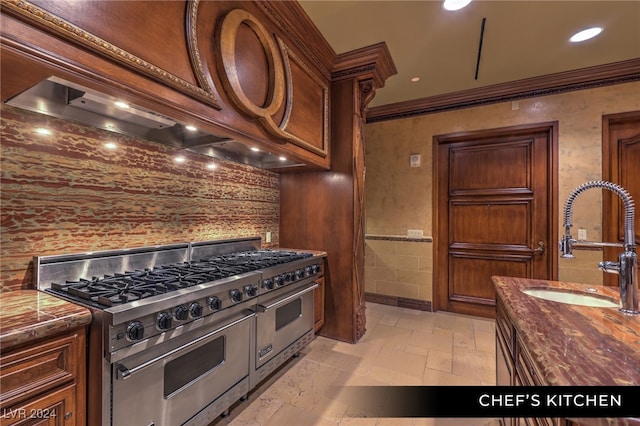 kitchen with wood counters, range with two ovens, sink, and ornamental molding