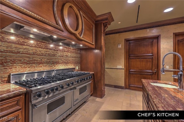 9103 Alta Dr Unit 401, Las Vegas, NV 89145 - kitchen featuring range with two ovens, ornamental molding, a sink, custom range hood, and stone tile floors