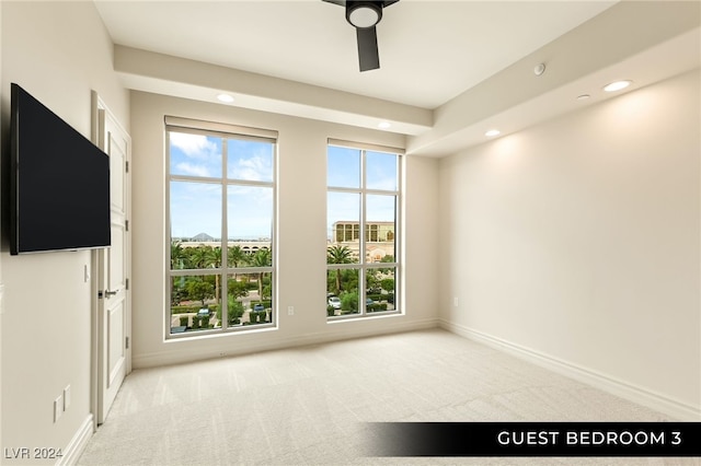 spare room with ceiling fan, light colored carpet, and a healthy amount of sunlight