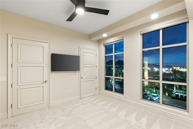 unfurnished living room featuring carpet and ceiling fan