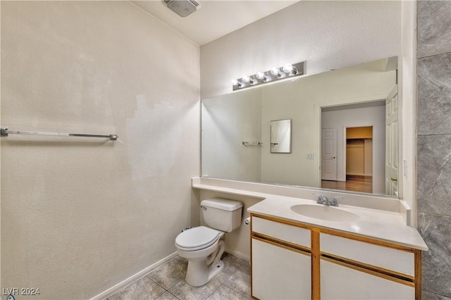 bathroom with tile patterned flooring, baseboards, vanity, and toilet