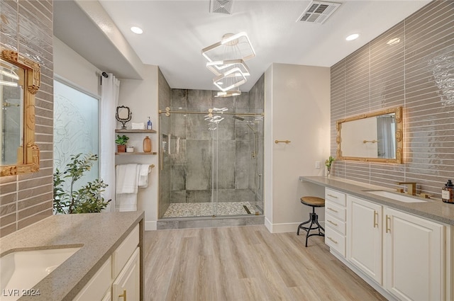 bathroom with vanity, an enclosed shower, decorative backsplash, and hardwood / wood-style flooring