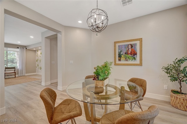 dining area featuring an inviting chandelier and light hardwood / wood-style floors