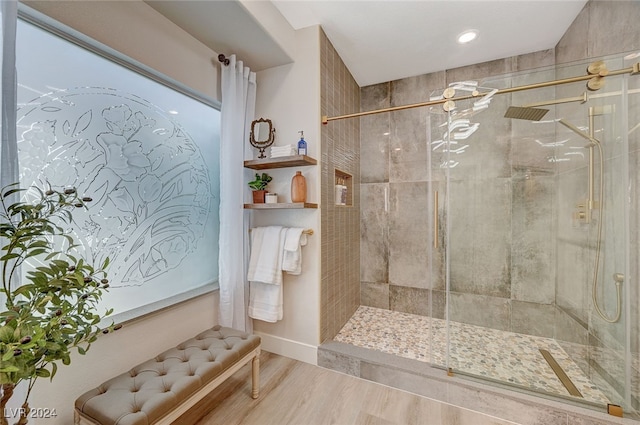 bathroom featuring hardwood / wood-style floors and a tile shower