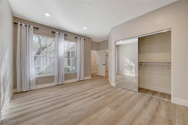 unfurnished bedroom with light hardwood / wood-style floors and a closet