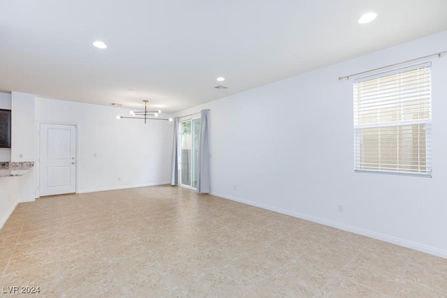 unfurnished living room with a chandelier