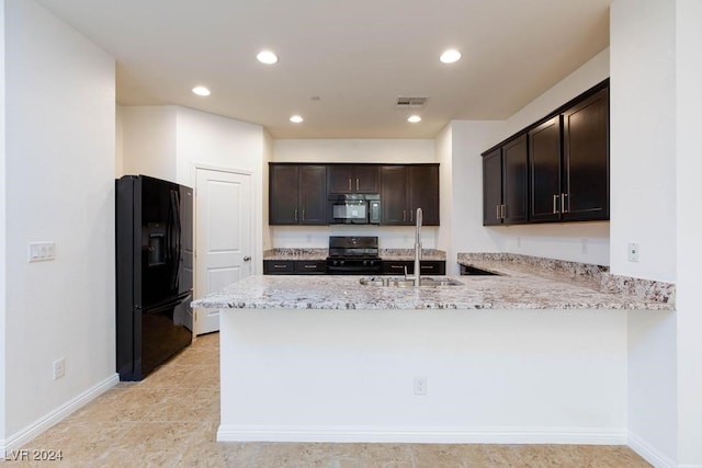 kitchen featuring black appliances, light stone counters, dark brown cabinetry, sink, and kitchen peninsula