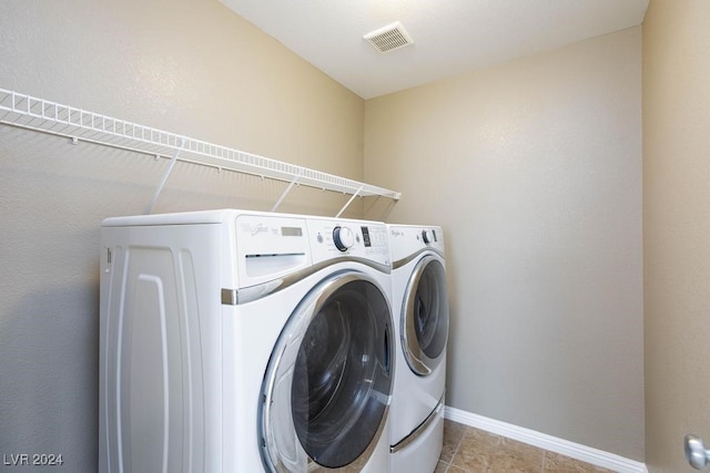 washroom with light tile patterned flooring and washer and dryer