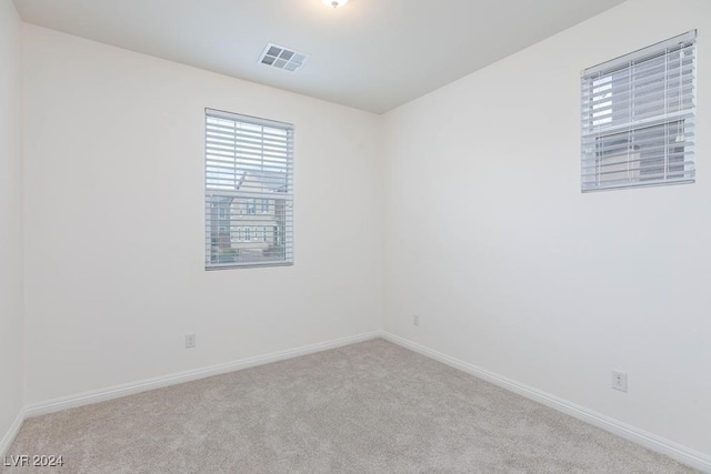 unfurnished room featuring light colored carpet