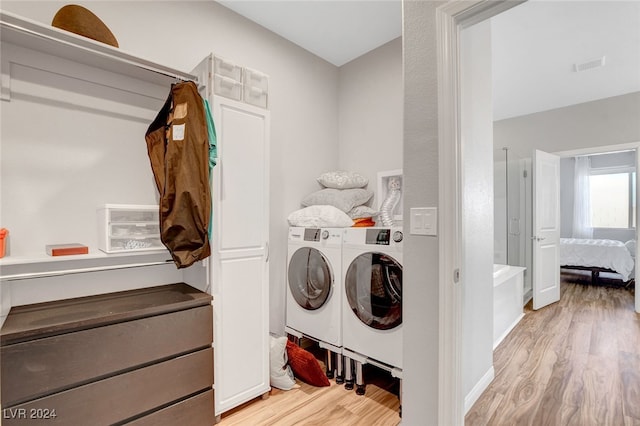 clothes washing area featuring washer and dryer and light wood-type flooring