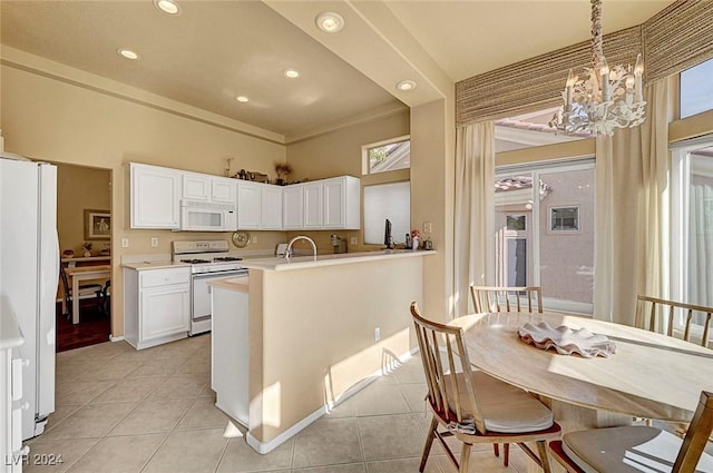 kitchen with white appliances, light tile patterned floors, a chandelier, white cabinetry, and hanging light fixtures