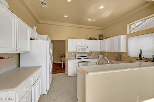 kitchen featuring sink, white cabinets, kitchen peninsula, white appliances, and light tile patterned floors