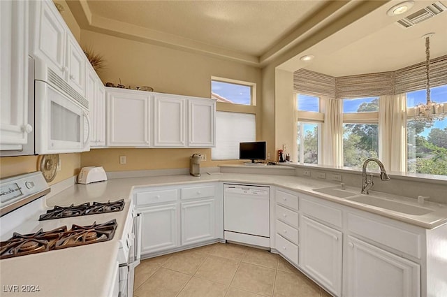 kitchen with white cabinetry, a healthy amount of sunlight, and white appliances