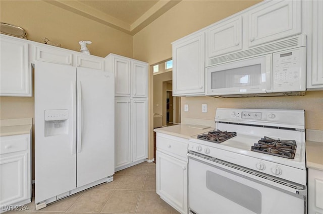 kitchen featuring white cabinetry, light tile patterned floors, and white appliances