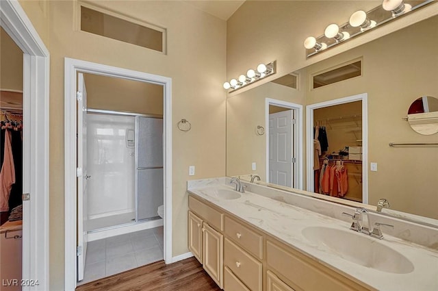 bathroom with toilet, a shower with door, vanity, and hardwood / wood-style flooring