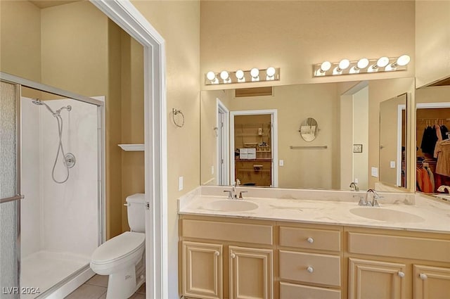 bathroom with tile patterned floors, vanity, toilet, and walk in shower