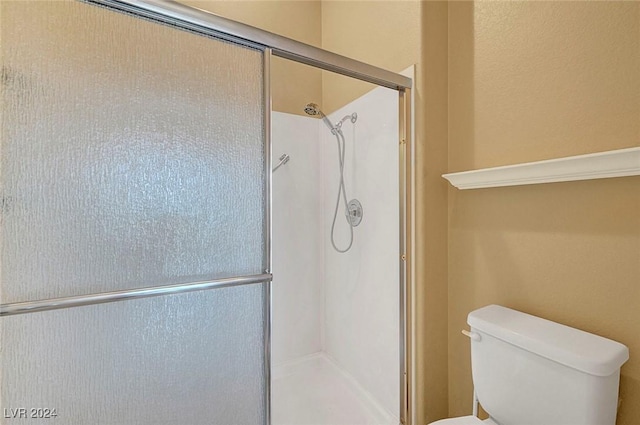 bathroom with toilet and an enclosed shower