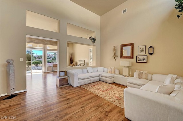 living room featuring a high ceiling and hardwood / wood-style flooring