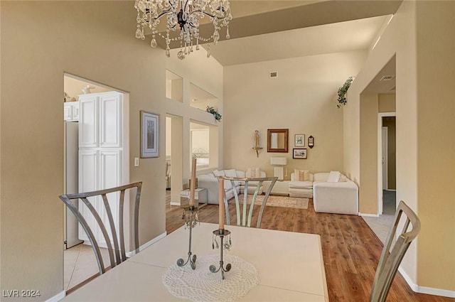 dining space with light hardwood / wood-style floors and a notable chandelier