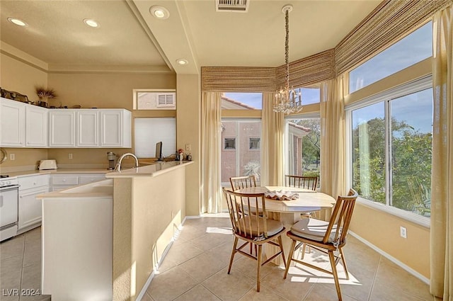 kitchen with white cabinets, a notable chandelier, pendant lighting, and light tile patterned flooring