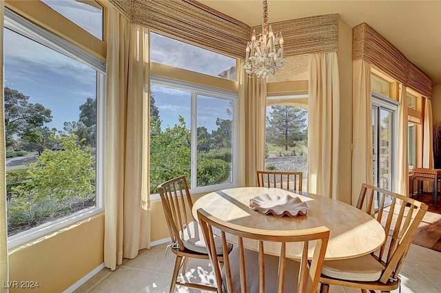 tiled dining room featuring plenty of natural light and a notable chandelier