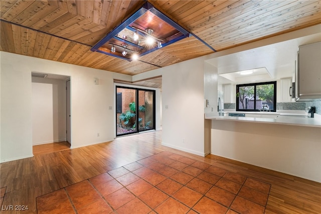 unfurnished living room featuring wood-type flooring and wooden ceiling