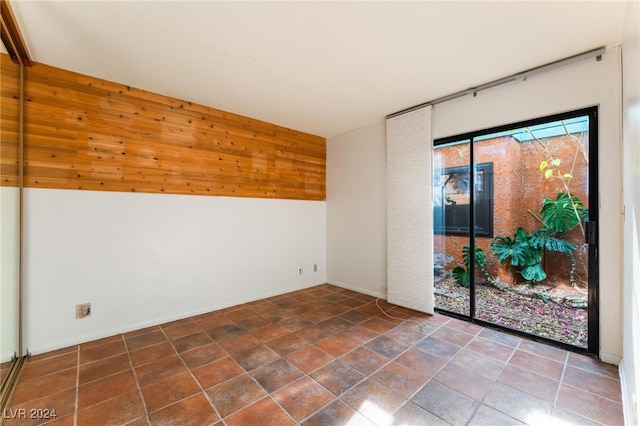 unfurnished room with wooden walls