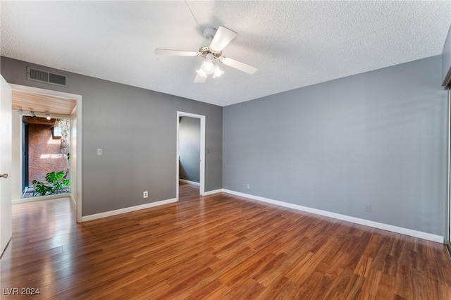 spare room featuring dark hardwood / wood-style flooring, a textured ceiling, and ceiling fan