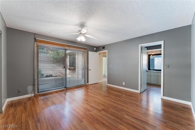 unfurnished room featuring wood-type flooring, a textured ceiling, and ceiling fan