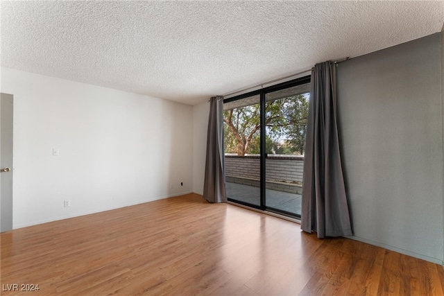 empty room with light hardwood / wood-style floors and a textured ceiling