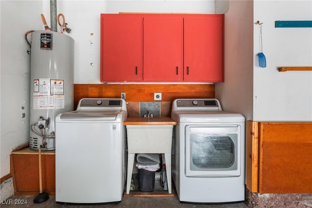 washroom featuring water heater, cabinets, and independent washer and dryer