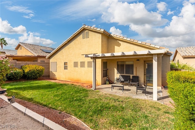 rear view of property featuring a yard and a patio area