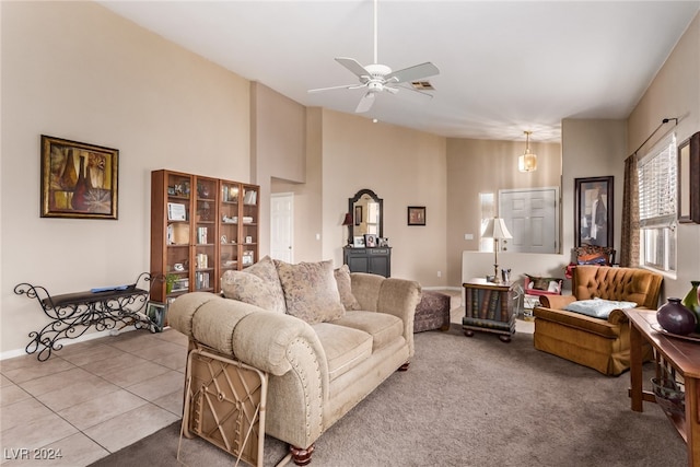 living room with a towering ceiling, ceiling fan, and tile patterned flooring