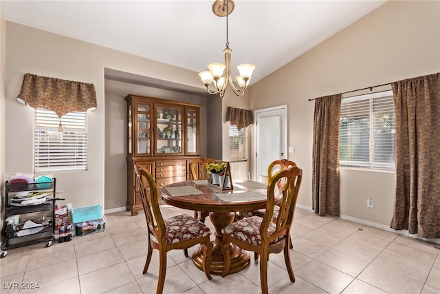 tiled dining room featuring a wealth of natural light, a chandelier, and vaulted ceiling