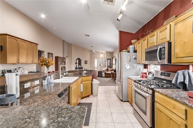 kitchen featuring light tile patterned flooring, stainless steel appliances, sink, vaulted ceiling, and ceiling fan