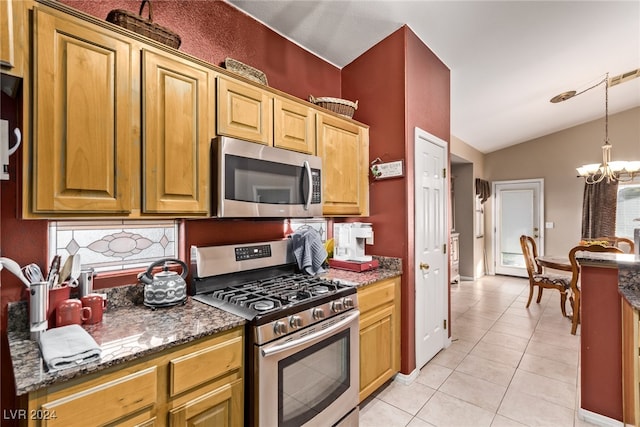 kitchen featuring stainless steel appliances, dark stone counters, vaulted ceiling, a notable chandelier, and light tile patterned floors