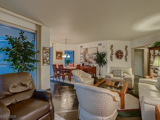 living room featuring a notable chandelier and dark tile patterned floors