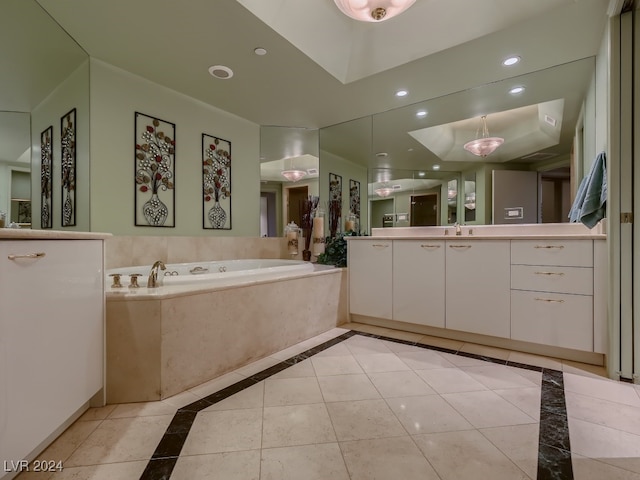 bathroom featuring a relaxing tiled tub, tile patterned floors, and vanity