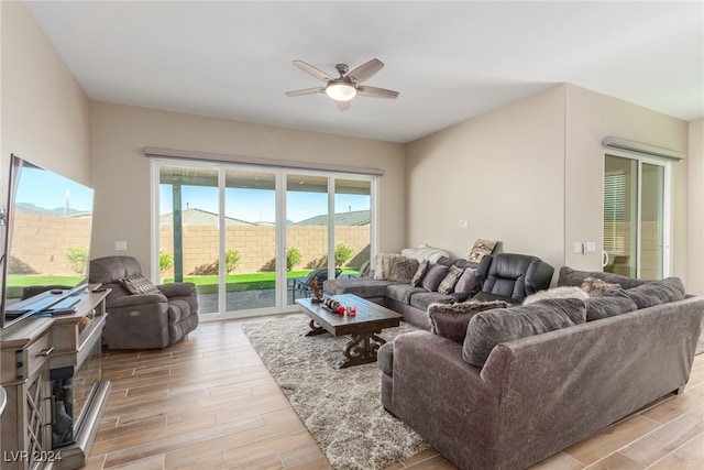 living room with light wood-type flooring and ceiling fan