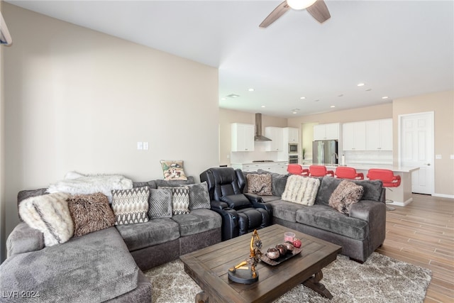 living room with light hardwood / wood-style floors and ceiling fan