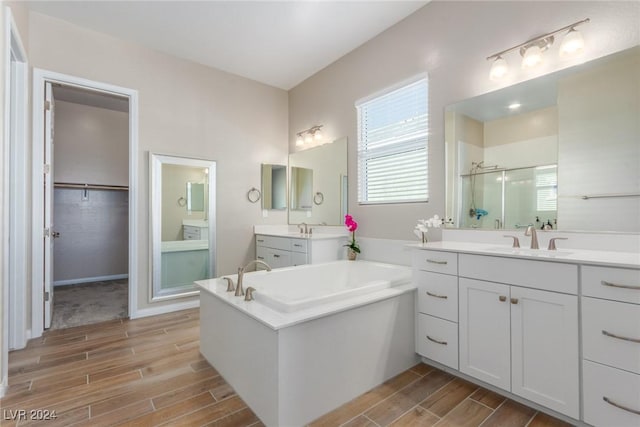 10254 Baronia St, Las Vegas, NV 89141 - bathroom with wood tiled floors, a shower stall, a bath, and two vanities