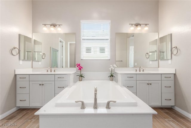10254 Baronia St, Las Vegas, NV 89141 - full bathroom with wood finished floors, a bath, and two vanities