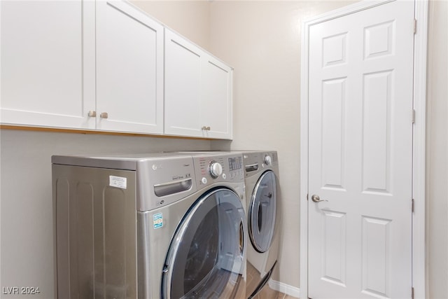 washroom with cabinets and washer and clothes dryer