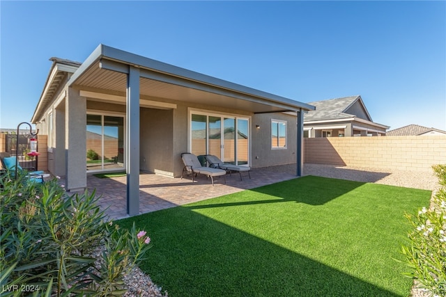 back of house with a lawn and a patio area